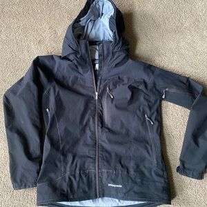 Patagonia black rain jacket. Zippered removable hood. Several zippered pockets.
